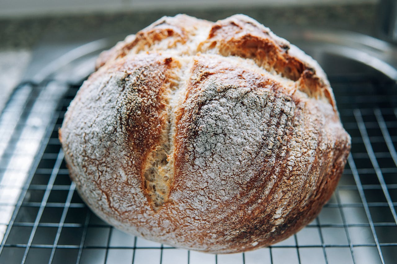 Crispy homemade artisan bread with a golden crust, cooling on a wire rack.
